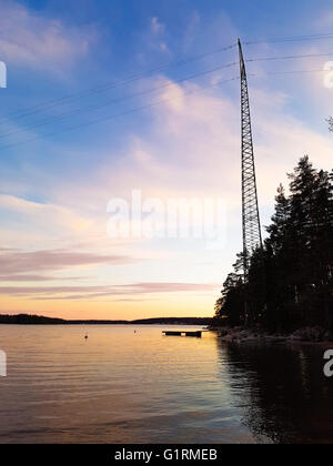 Ligne électrique au-dessus de l'eau, à une soirée, à Raasepori, Uusimaa, Finlande Banque D'Images