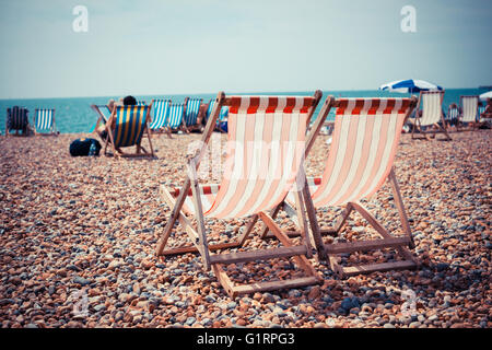 Deux chaises longues sur une plage de galets Banque D'Images