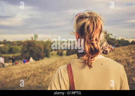 Une jeune femme est en admirant la vue sur la ville depuis une colline dans le parc Banque D'Images