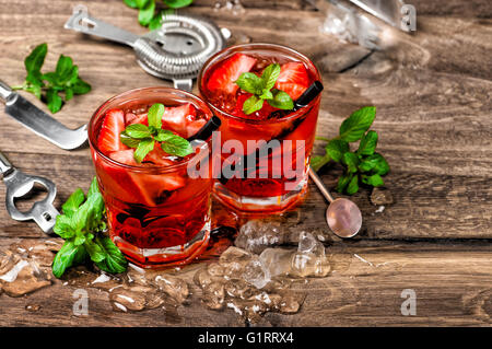 Cocktail rouge avec de la glace, les feuilles de menthe et fraise. Boissons alcoolisées et non alcoolisées décisions outils barre Banque D'Images