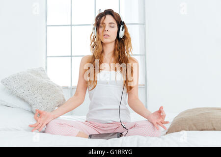 Woman meditating on le lit à la maison Banque D'Images