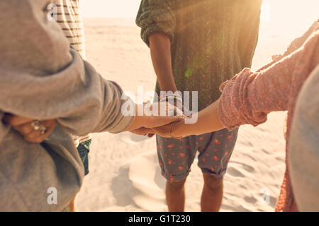 Groupe d'amis leur pile les mains ensemble. Les jeunes hommes et femmes se tenant ensemble à la plage, les mains d'empilage de concept Banque D'Images