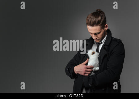 Attractive young woman holding et sur fond gris lapin Banque D'Images