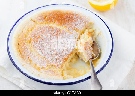 Pudding cake au citron avec les citrons frais sur un fond de bois blanc. Banque D'Images