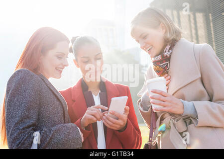 Les femmes sms et de boire du café en plein air Banque D'Images