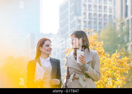 Businesswomen walking avec café en ville Banque D'Images