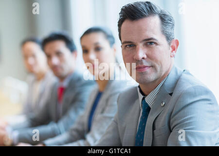 Portrait of businessman et collègues dans une rangée Banque D'Images