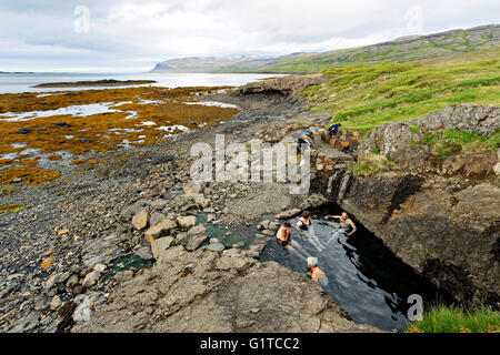 Groupe de personnes se baignant dans une source thermale naturelle ( Hellulaug Vatnsfjšrdur), fjord, Westfjords, l'Islande, l'Europe. Banque D'Images