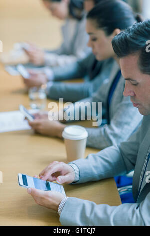 Businessman using cell phone in conference room Banque D'Images
