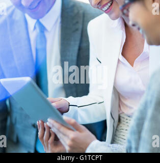 Smiling business people using digital tablet Banque D'Images