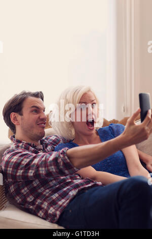 Playful couple making faces selfies en tenant Banque D'Images