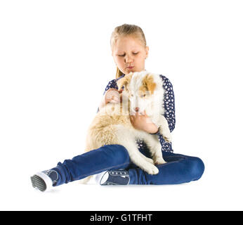 Petite fille et border collie puppy.enfant jeune chien isolé sur fond blanc. Banque D'Images