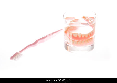 Dentier dans le verre d'eau et brosse à dents Banque D'Images