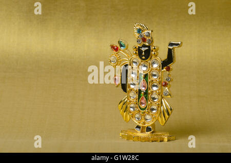 Petite idole féminine (miniature) de tirupati sur le fond doré, studio shot, Pune, Maharashtra, Inde Banque D'Images