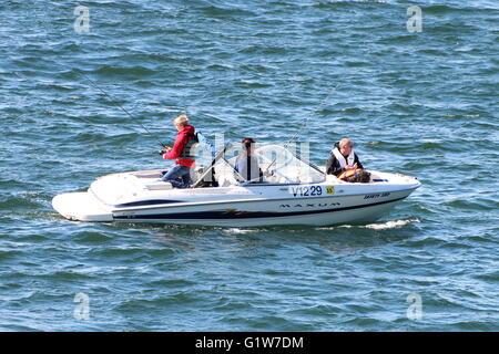 Les occupants d'un petit bateau de moteur /bateau faire un spot de pêche en mer au large de Gourock sur le Firth of Clyde. Banque D'Images