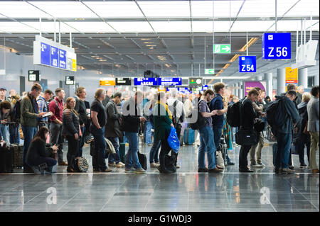 Les passagers qui attendent dans une rangée pour l'embarquement sur un aéroport pour un vol vers l'Amérique Banque D'Images