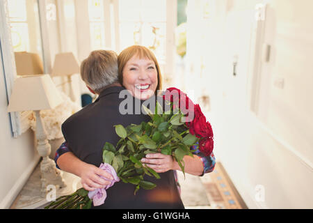 Heureux les femmes recevant le bouquet de rose et s'étreindre mari Banque D'Images