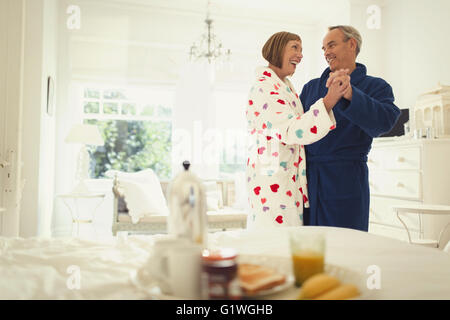 Mature couple dancing in peignoirs dans la chambre Banque D'Images