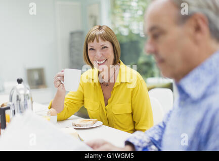 Portrait of smiling mature woman drinking coffee at table de petit déjeuner Banque D'Images