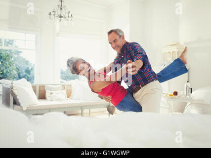 Maturité ludique couple dancing in living room Banque D'Images