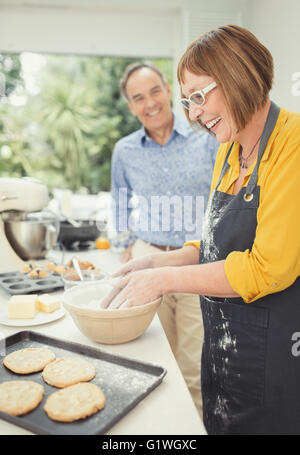 Mature couple baking cookies dans la cuisine Banque D'Images