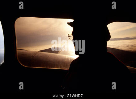 Voyageur d'aventure en avion au-dessus de l'air charte Bering Bering Sea at sunset ; URSS, Russie : la Sibérie : Alaska Banque D'Images