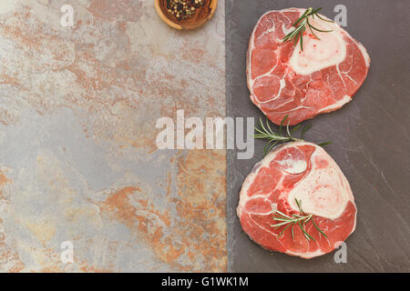 Jarret de veau pour l'osso bucco. La viande crue avec herb et poivre noir pour la cuisson Banque D'Images