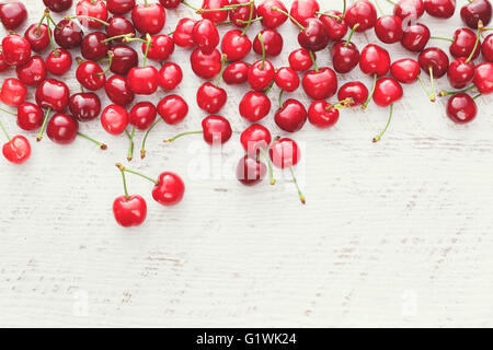 Cerises fraîches. Cerises fraîchement cueillies sur table en bois Banque D'Images