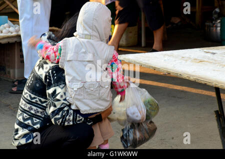 Thai mère son fils et acheter de la nourriture pour manger au matin à l'heure du marché local Banque D'Images