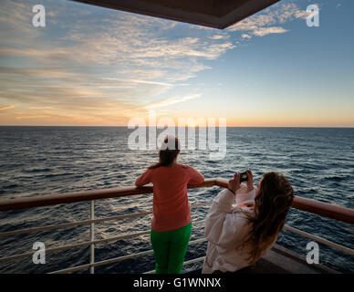 Femme prenant une photo du coucher de soleil avec un téléphone intelligent appareil photo. Banque D'Images