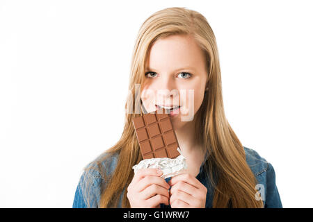 Fille de mordre une barre de chocolat Banque D'Images