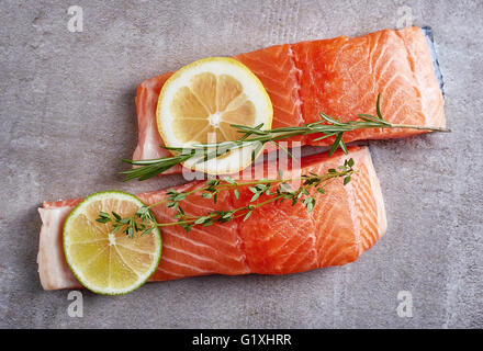 Deux nouvelles matières filet de saumon à l'aide de chaux, de citron et d'épices sur le tableau gris, vue du dessus Banque D'Images