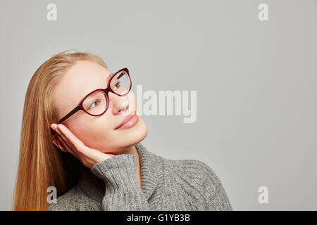 Young blonde woman daydreaming looking up Banque D'Images