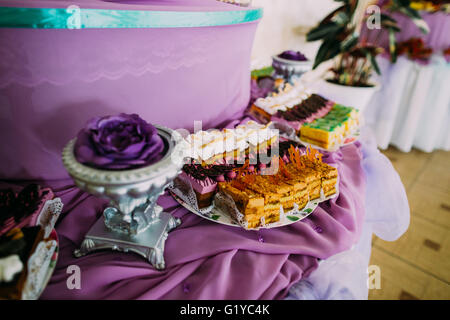 Table dessert sucré ou candy bar. Fête de mariage. La lumière naturelle. Macaron, pyramide de meringue, de gâteaux et de la guimauve Banque D'Images