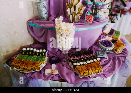 Table dessert sucré ou candy bar. Fête de mariage. La lumière naturelle. Macaron, pyramide de meringue, de gâteaux et de la guimauve Banque D'Images