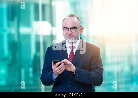 Businessman typing sur smartphone Banque D'Images