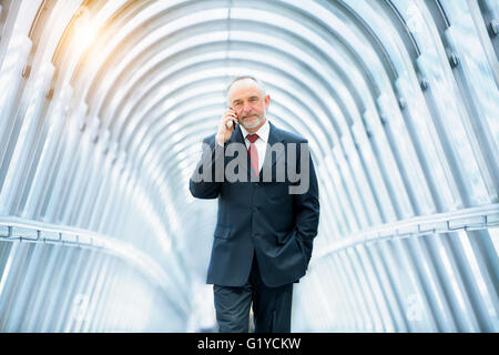 Businessman talking on mobile phone in financial district Banque D'Images