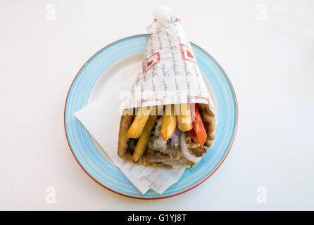 Les gyros de porc avec salade et frites enveloppé dans une assiette en Grèce Banque D'Images