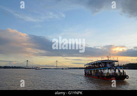 Des bateaux de transport sur le fleuve Hooghly sur un coucher du soleil la mousson, Kolkata, West Bengal, India Banque D'Images