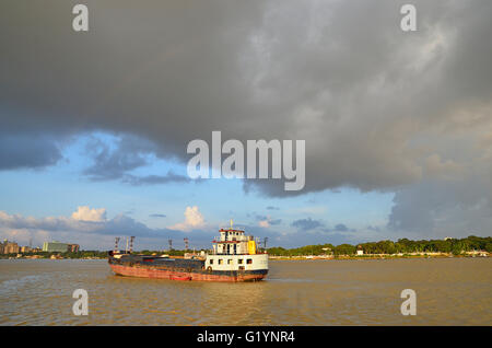 Des bateaux de transport sur le fleuve Hooghly sur un coucher du soleil la mousson, Kolkata, West Bengal, India Banque D'Images