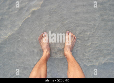 Men's feet on the beach. Banque D'Images