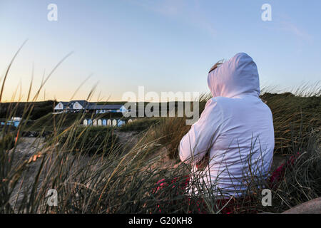 Femme regardant le coucher du soleil sur la plage de Cornouailles en Angleterre Banque D'Images