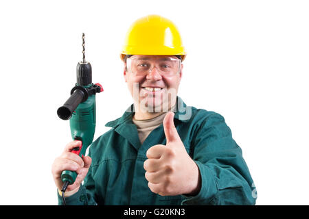 Smiling repairman avec une perceuse gesturing Thumbs up, en se concentrant sur le pouce, selective focus Banque D'Images