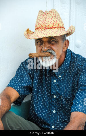 La HAVANE, CUBA - le 6 juin 2013 homme cigare cubain de fumée tout en regardant dans la rue sur l'appareil photo à La Havane, Cuba. Banque D'Images