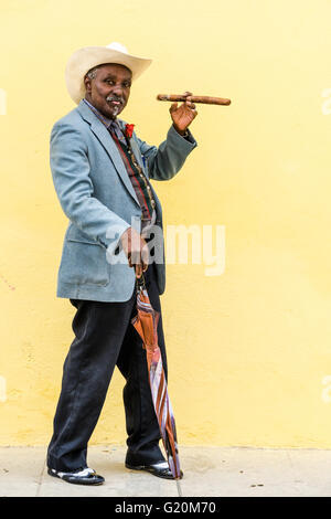 La Havane, Cuba - 27 septembre 2015 : big man smoking traditionnels cubains cigare cubain sur fond mur jaune à La Havane, Cuba Banque D'Images