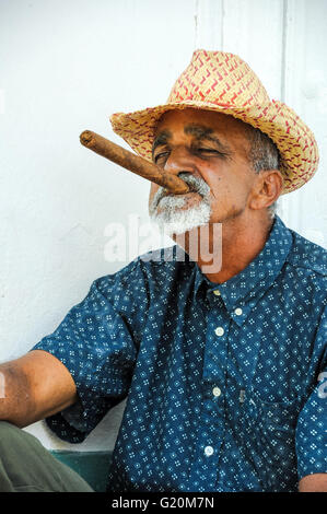 La HAVANE, CUBA - le 6 juin 2013 homme cigare cubain de fumée tout en regardant dans la rue sur l'appareil photo à La Havane, Cuba. Banque D'Images