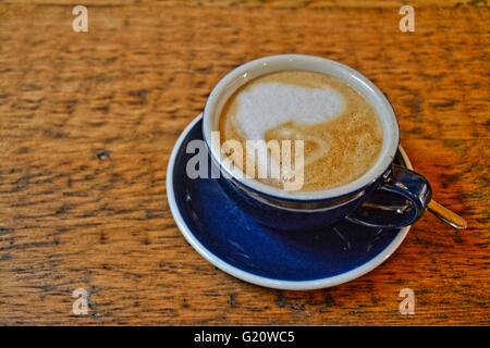 Tasse de café crémeux, voie lactée fin, sur une table en bois brun, bleu, dans une tasse. Banque D'Images