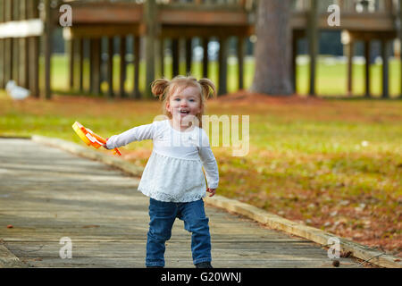 Bébé Enfant fille avec guitare jouet walking in l'autumn park Banque D'Images