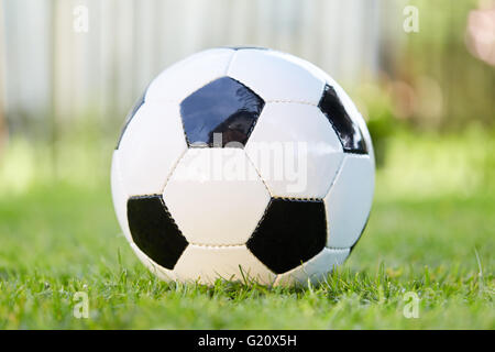 De Football jeu de foot allongé sur l'herbe verte du jardin Banque D'Images