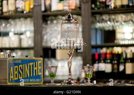 Nuremberg, Allemagne. 19 mai, 2016. Une absinthe fontaine vu sur le comptoir à la barre de la 'Casablanca' cinéma à Nuremberg, Allemagne, 19 mai 2016. Les cuillères en métal perforé avec crochets sont conçus pour s'adapter sur les verres à absinthe afin que le sucre en cubes, qui sont placés sur le haut de la cuillère, se dissout par l'eau de la glace dégoulinant fontaine absinthe. Tujon-contenant l'absinthe était interdit en Allemagne et la plupart de l'Europe depuis des décennies. Aujourd'hui, la boisson spiritueuse, faite à partir de la plante d'absinthe, est devenu un établissement emblématique boisson culte. Photo : DANIEL KARMANN/dpa/Alamy Live News Banque D'Images